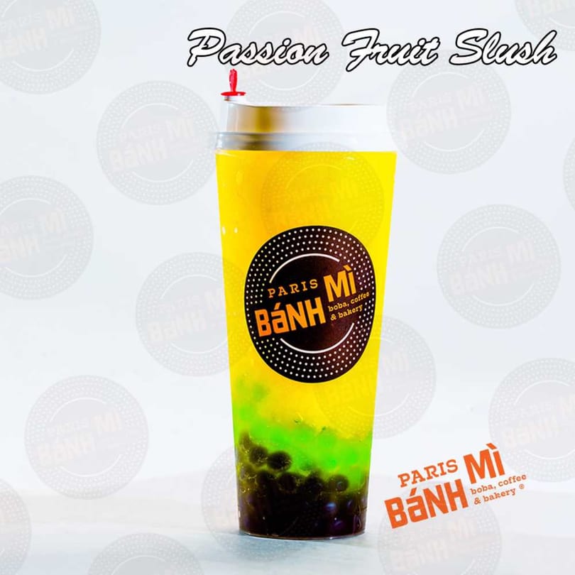 A Paris Banh Mi Passion Fruit Slush with yellow and green layers and dark boba pearls.