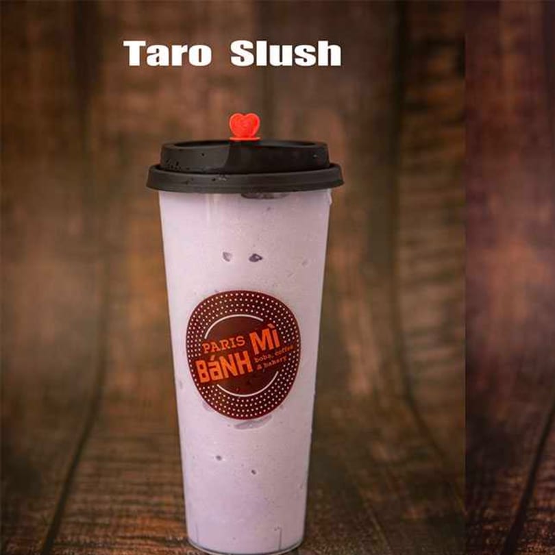 Taro Slush drink from Paris Banh Mi Augusta, in a clear cup with a black lid and red heart.